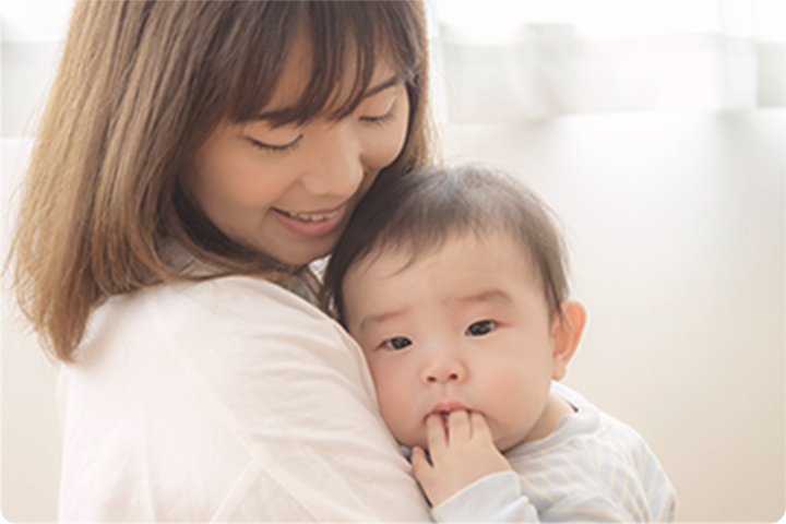 赤ちゃんを優しく抱きしめるお母さん
