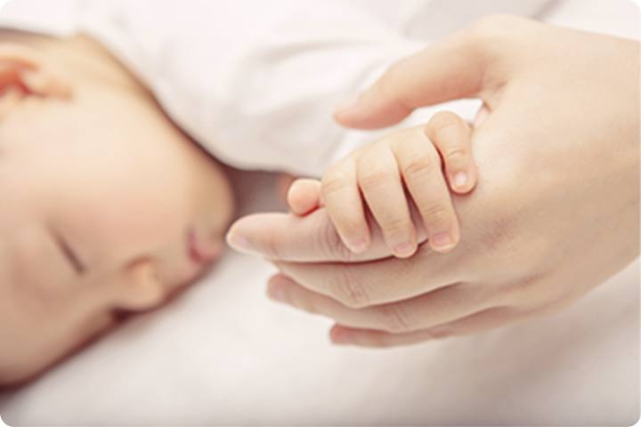 大人の手に包まれた赤ちゃんの手
